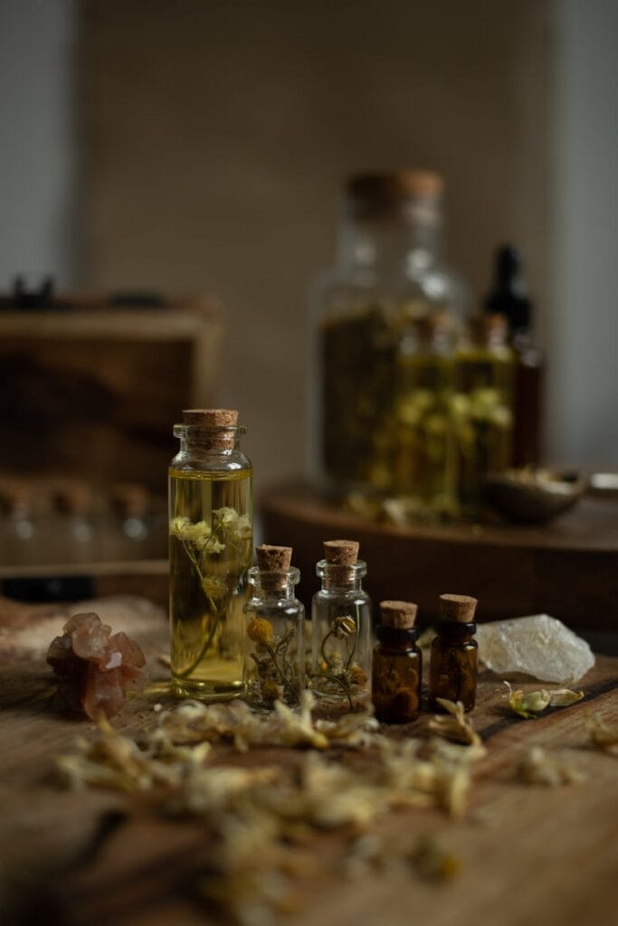 A collection of rustic glass bottles with aromatic herbs on a wooden table, perfect for aromatherapy themes. shaman