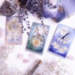 deck of tarot cards beside dried flowers and crystals on a white surface. Divination. Shaman